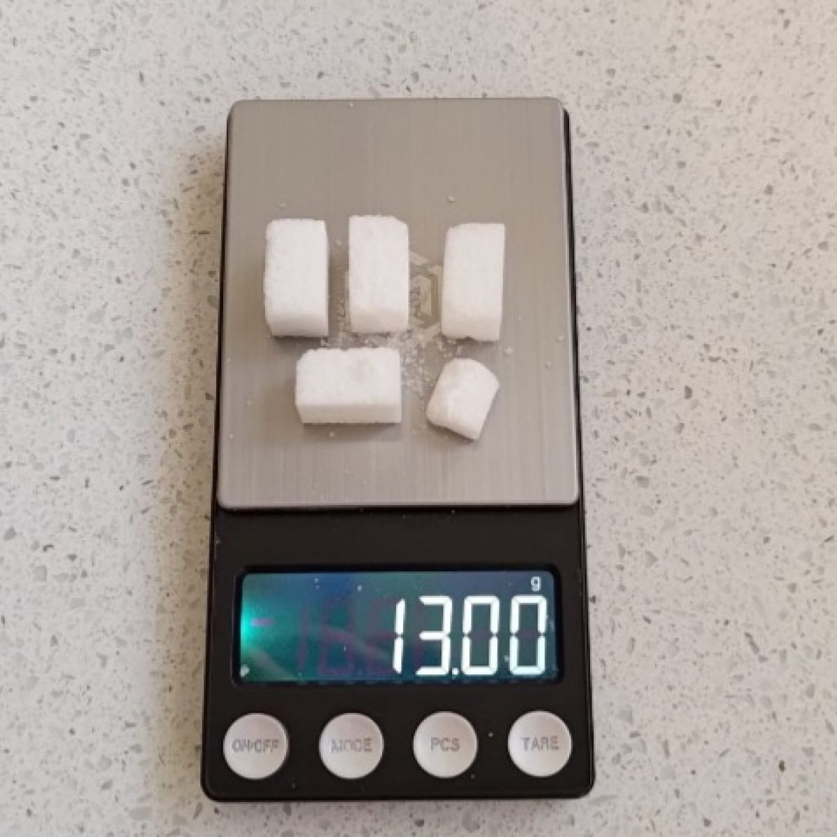 weegschaal met 5 suikerklontjes